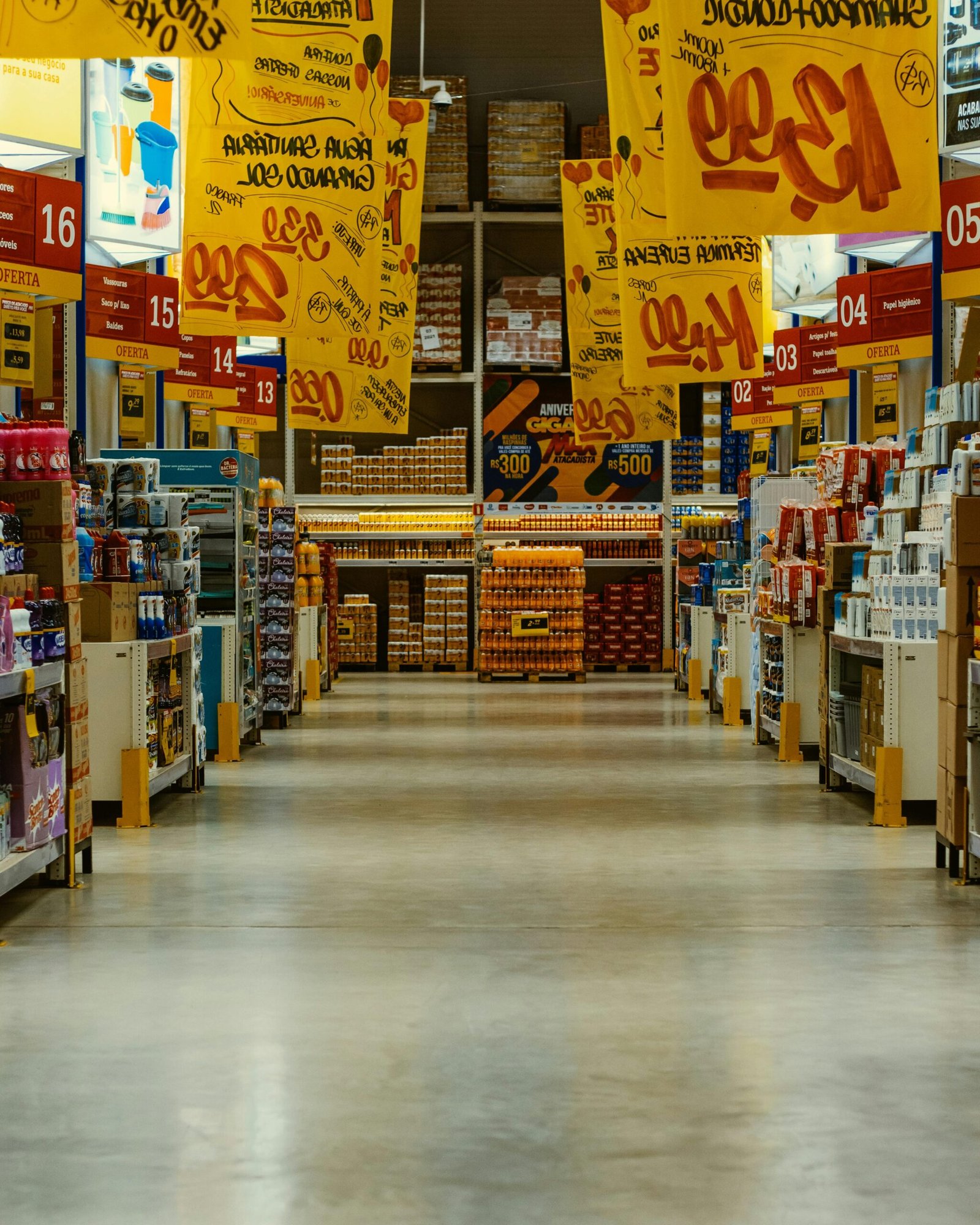 Wide supermarket aisle with colorful sale banners and stocked shelves in a vibrant Brazilian store.
